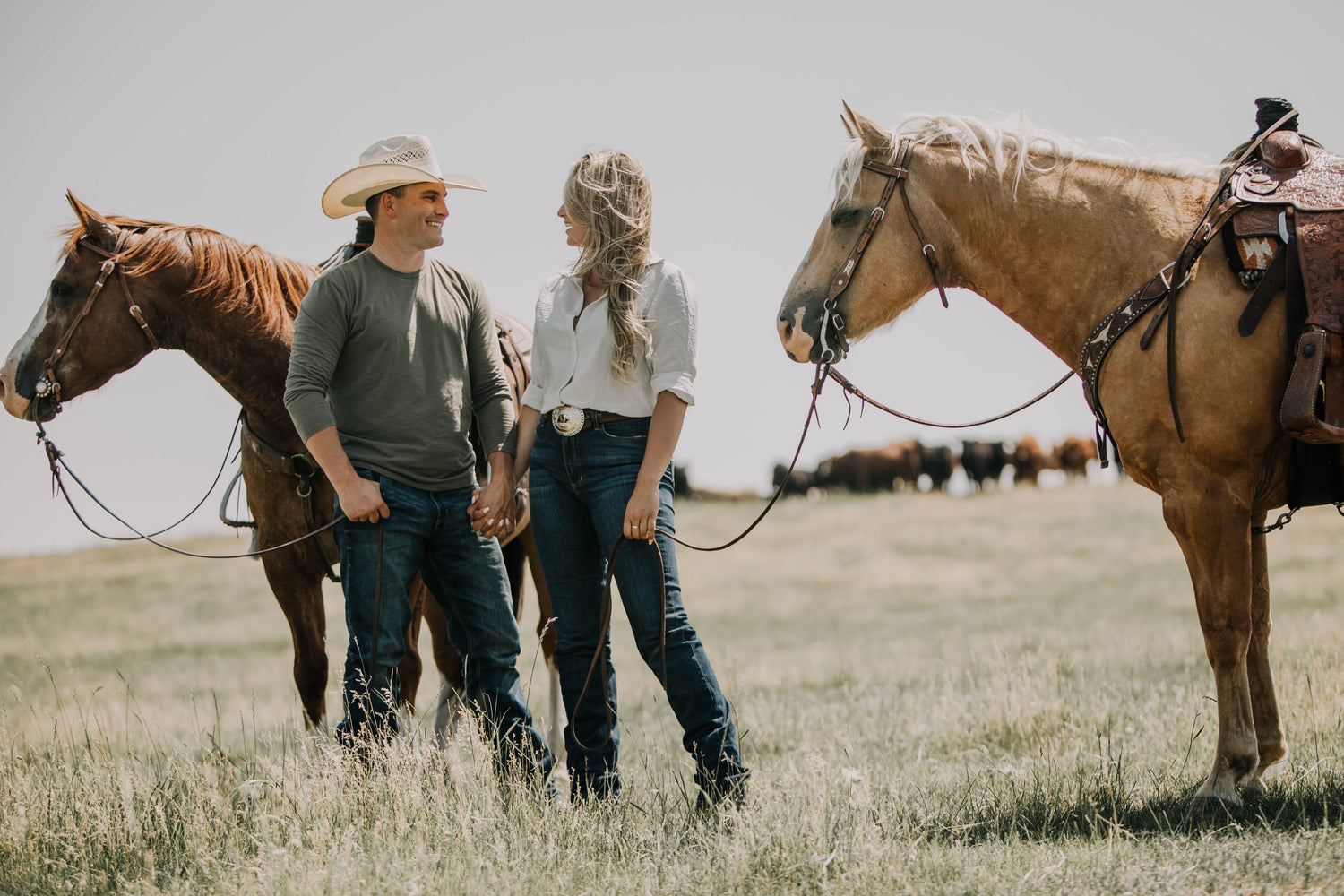 Marie Fraser and Michael Holmes standing with horses on their Alberta ranch
